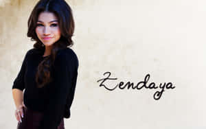 Zendaya 穿著黑色上衣，在名字旁邊微笑。