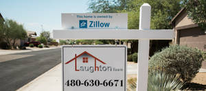 沙漠郊區社區中 Zillow 和 Laughton Team 的房地產標誌。 — 灰色 GIF 壁紙