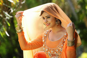 身穿傳統橙色服裝的女士微笑著，雙手在戶外掀起面紗。 — 女孩 壁紙