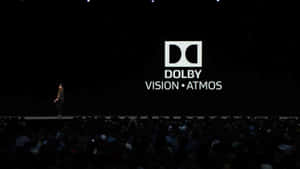 科技活動舞台上，演講者身後顯示Dolby Vision Atmos標誌。 — 風景動圖 壁紙