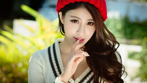 年輕女子戴著紅色帽子和白色毛衣在戶外觸摸嘴唇。 — 女孩 壁紙