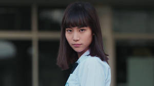 穿著校服的年輕女性在戶外看著相機 — Netflix GIF 壁紙