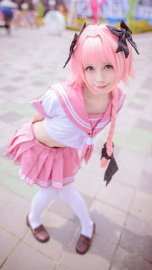 一位穿著粉紅色水手服的cosplayer，編髮和黑色蝴蝶結，對著鏡頭微笑。 — 可愛動漫女仔 壁紙