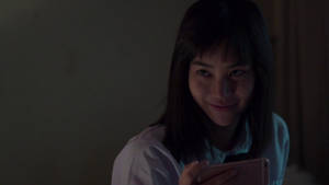 年輕女性在黑暗房間中看著手機微笑 — Netflix GIF 壁紙