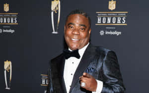 身穿黑色燕尾服和蝴蝶結的男子在NFL Honors活動中微笑。