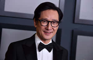 身穿燕尾服和眼鏡的男子對著鏡頭微笑 — 胡桃 壁紙