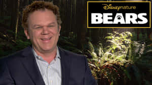 西裝男子在森林前微笑，帶有DisneyNature Bears標誌。 — 基斯柏特 壁紙