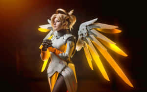 Cosplayer打扮成《鬥陣特攻》慈悲，在昏暗的攝影棚中展現發光翅膀。 — 2880x1800 壁紙