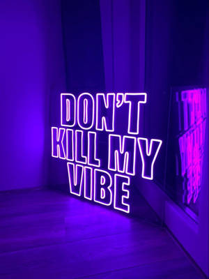 霓虹燈牌在木地板上以紫色燈光顯示 don't kill my vibe。