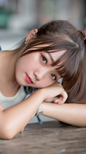 年輕女子將下巴擱在雙臂上凝視鏡頭 — 女孩 壁紙