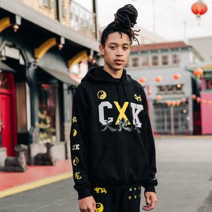 穿著街頭服飾的年輕人站在唐人街，背景有紅色燈籠和傳統建築。 — 火影忍者海報 壁紙
