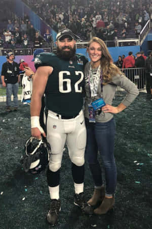 足球運動員和女性在比賽後於體育場上擺姿勢。 — NFL 美式足球 GIF 壁紙
