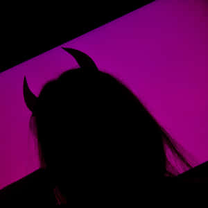 一個戴著惡魔角的人影，襯托著紫色燈光。