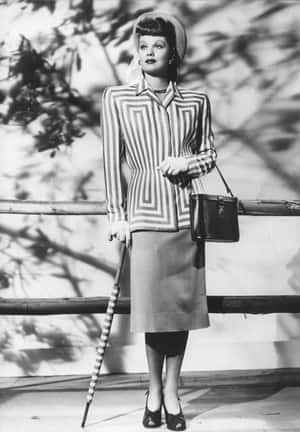 1940年代穿著幾何條紋西裝的女士，在戶外手持雨傘和手袋。 — 黑白美學 壁紙