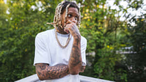 紋身男子辮子頭穿白色T恤靠在戶外欄杆上 — Lil durk GIF 壁紙