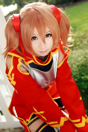 身穿紅金色服裝、橙色雙馬尾的動漫cosplayer，戶外。 — 刀劍神域 GIF 壁紙