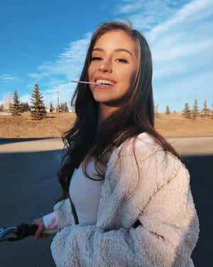 年輕女性在陽光明媚的日子裡微笑著在戶外騎自行車。 — 美學女孩 壁紙