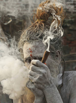 一位皮膚上有灰的聖人從煙斗中呼出煙。 — 食草 壁紙