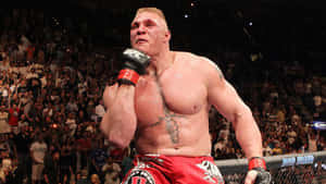 一位赤裸上身的MMA戰士在UFC八角籠中與歡呼的人群一起慶祝勝利。 — 拳擊 壁紙