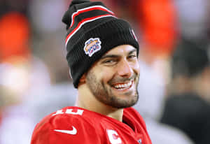 足球運動員在體育場活動中身穿紅色球衣和黑色冷帽微笑。 — NFL 美式足球 GIF 壁紙