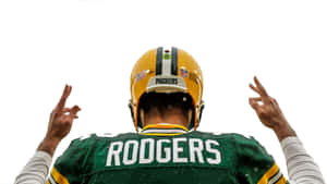 身穿包裝工裝備的足球運動員 Rodgers 高舉雙手慶祝。 — 綠灣包裝工 GIF 壁紙