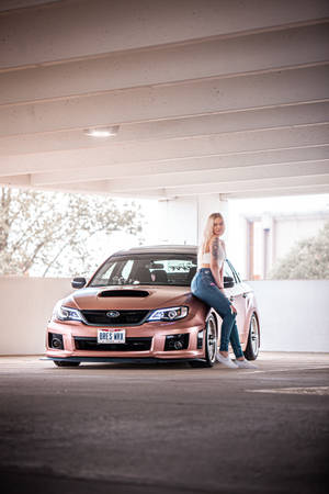 穿著牛仔褲和白色上衣的金髮女郎在天橋下靠在玫瑰金色的Subaru WRX上。 — 玫瑰金風格 壁紙