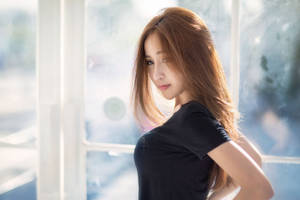 長棕髮女性身穿黑色T恤站在陽光照射的窗邊 — 女孩 壁紙