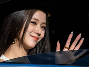 女士戴著金耳環和戒指，從車窗微笑揮手。 — 微笑 壁紙
