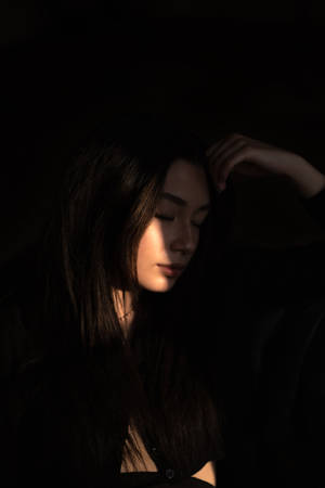 陰影中的女性，一手放在頭上，從側面柔和打光。 — 女孩 壁紙