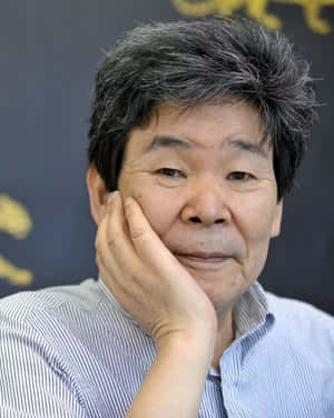 一位沉思的年長男性，在工作室肖像中將下巴擱在手上。 — 角落生物 壁紙