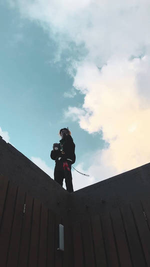 一個人企喺木籬笆頂，喺晴朗有雲嘅天空下。 — 風景動圖 壁紙