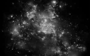 一個充滿恆星和發光宇宙雲的旋轉星系，以黑白呈現。 — 最黑暗地牢 壁紙