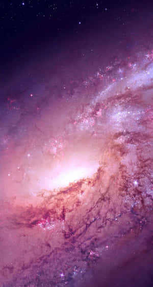 一個發光的螺旋星系，帶有粉紅色和紫色的雲彩以及閃爍的星星。 — 銀河系 壁紙