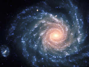 螺旋星系，核心明亮，藍色旋臂上佈滿恆星，在深空中。 — 銀河系 壁紙