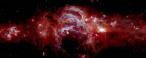 在深空中，帶有閃爍星星的鮮豔紅色和紫色星雲。 — 超寬螢幕 壁紙