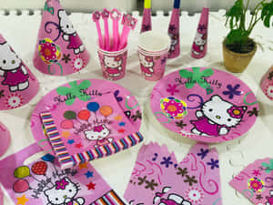 Hello Kitty派對用品，包括碟、杯、帽子和餐巾，放在白色桌子上。 — Hello kitty 美學 GIF 壁紙
