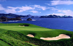 沿海高爾夫球場，享有海景和連綿起伏的綠色山丘，天空晴朗。 — 夏天 壁紙