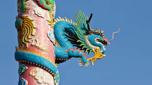 在清澈的藍天下，色彩繽紛的陶瓷龍雕塑纏繞在裝飾柱上。 — 藍天 壁紙