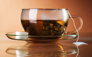一個玻璃茶杯，帶有茶包和方糖，放在反光的碟子上。 — 青綠色 GIF 壁紙