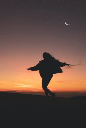 暮色山丘上，一個人嘅剪影喺星星同月亮下跳舞。 — 月色夜空 壁紙