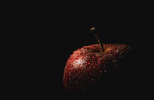 一個帶水滴的紅蘋果在黑色背景上。 — 黑色動態圖 壁紙