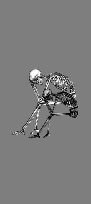 一個骷髏人物低頭沉思。 — Pixel 11 壁紙