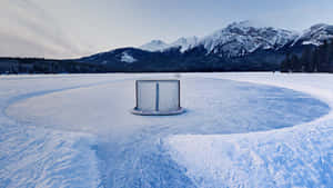 冰凍湖面上的曲棍球網，背景是白雪覆蓋的山脈 — 冰 GIF 壁紙