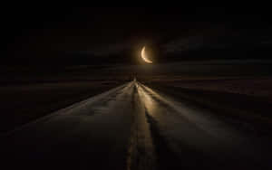 一個人在夜晚的彎月下獨自走在濕漉漉的道路上。 — 黑暗森林 壁紙