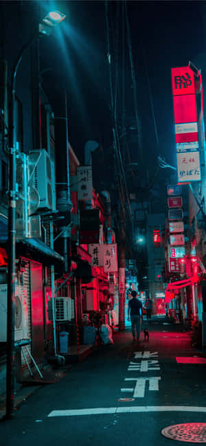 一個人在夜晚走下一條霓虹燈照亮的東京小巷，伴有紅色和藍色的燈光。 — 夜景城市 壁紙