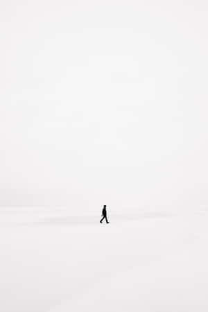 一個人在廣闊的雪景中獨自行走。 — 極簡美學 壁紙