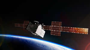 衛星在地球上空的軌道上，太陽能板展開 — 昏暗 壁紙