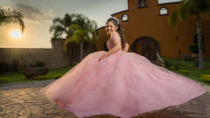 女孩穿著粉紅色 quinceanera 禮服在夕陽下的棕櫚樹庭院中旋轉。 — 熱粉紅美學 壁紙