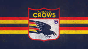 Adelaide Crows AFL球隊標誌，在深藍色背景上，盾牌上有一隻黑色的烏鴉，並有紅色和黃色條紋。 — iMac 壁紙