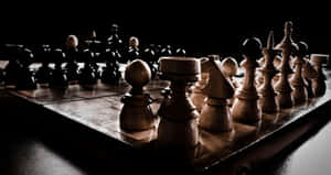 木製國際象棋棋子放在棋盤上，在戲劇性的聚光燈下，背景為黑色。 — 國際象棋 壁紙